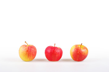 Line of three dewy apples with white background