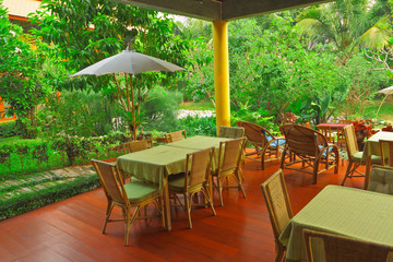 Relaxing area under the first floor among floral garden