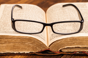reading glasses and old book