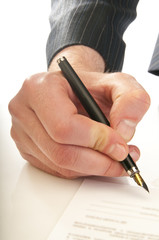 Human hand with pen makes signature
