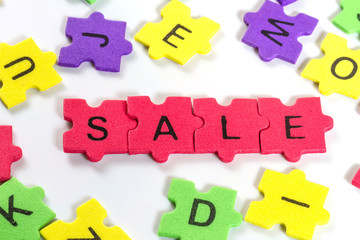 word SALE formed with colorful foam puzzle  on white background