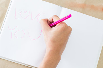 hands writing on the paper  , I love you