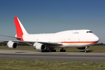 Fototapeta na wymiar Biały samolot towarowy z czerwonym ogonem