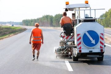 Two industrial workers during road surface marking