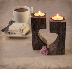 Cup of coffee on the background candlesticks in the shape of hea