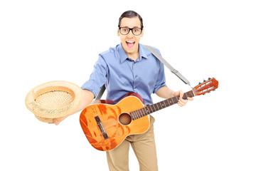 Young male guitarist bow down holding his hat