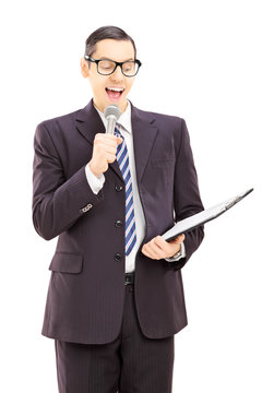 Young male presenter holding microphone and clipboard