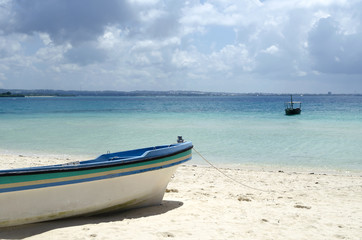 Naklejka na ściany i meble Fisherman boat on the beach with blue sky in Zanzibar, Tanzania