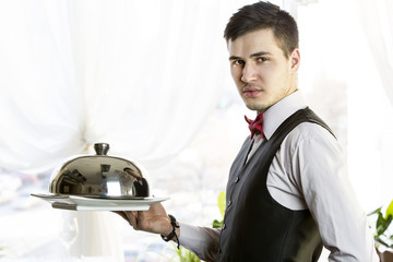 waiter with a tray of food in the restaurant hall