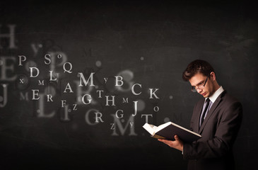 Young man reading a book with alphabet letters