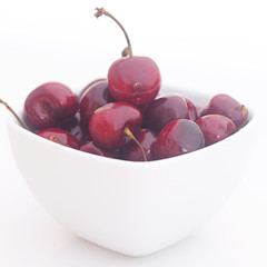 Cherries in a ceramic bowl isolated on white