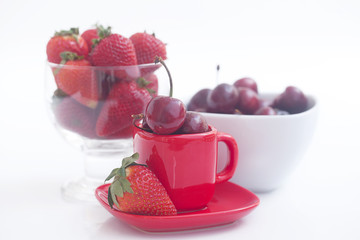 Cherries and strawberry in a ceramic and glass bowl isolated on