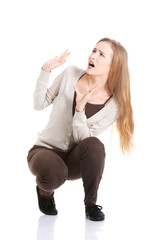 Beautiful casual woman is crouching from sth heavy above her.