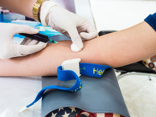 Doctor drawing blood sample from arm for blood test