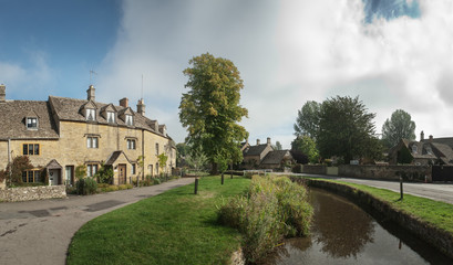 View of stream through a street in the Cotswold, England
