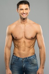 Fototapeta premium Handsome young man in blue jeans with naked torso