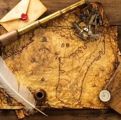 Different tools  on vintage map over wooden background