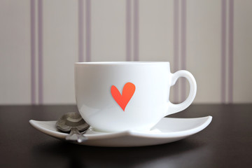 Cup of tea with heart shape on wooden table.