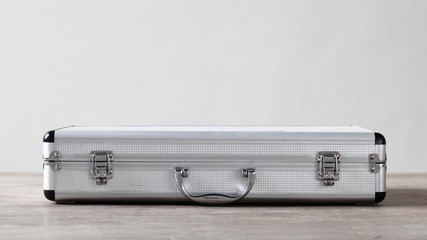 Aluminum suitcase on wooden table