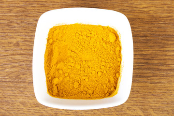 Curcuma, curry, yellow- orange spice in a bowl.