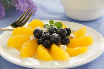 Delicious fruit salad with oranges, blueberries and cream.