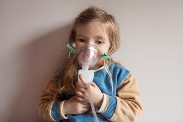 Little girl holding inhalation mask
