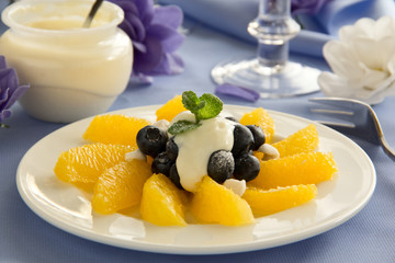 Delicious fruit salad with oranges, blueberries and cream.