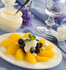 Delicious fruit salad with oranges, blueberries and cream.