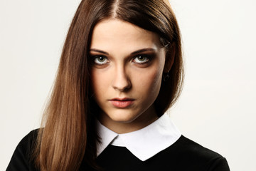 Closeup portrait of a young thoughtful woman on gray background