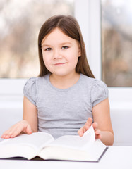 Little girl is reading a book