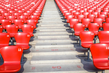 Red chairs bleachers in large stadium