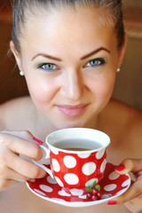 Beautiful woman holds the cup of cowberry tea