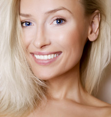 Portrait of blonde girl with toothy smile.