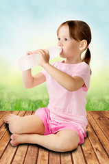 Cute little girl drinking clear water from bottle