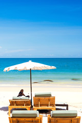 Beach chair and umbrella on sand beach.