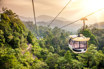 Fototapeta premium Aerial tramway moving up in tropical jungle mountains
