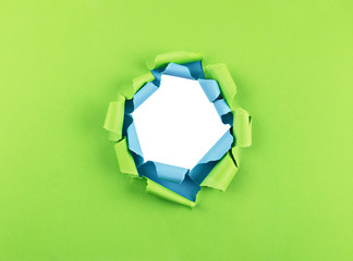 Loch in grünem und blauem Pappier