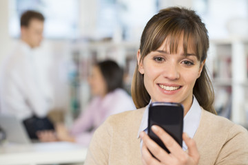 Cute businesswoman on mobile phone in office, sms, message