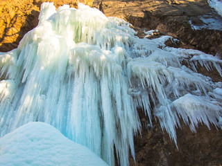 Frozen waterfall on a rock in the sunshine