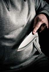 Robbers hand thrusting knife forward