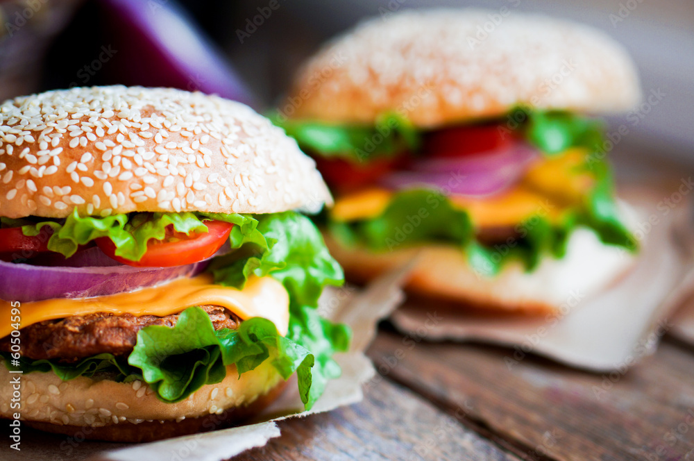 Wall mural Closeup of home made burgers on wooden background