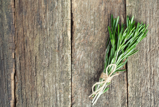 bunch of rosemary on wooden surface