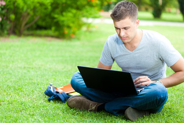 Student using laptop on the grass