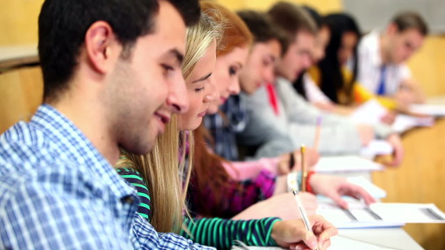 Row of happy students listening in a lecture hall