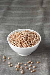 Organic chickpeas on sackcloth in ceramic bowl
