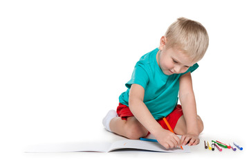 Naklejka premium Cute little boy drawing on paper