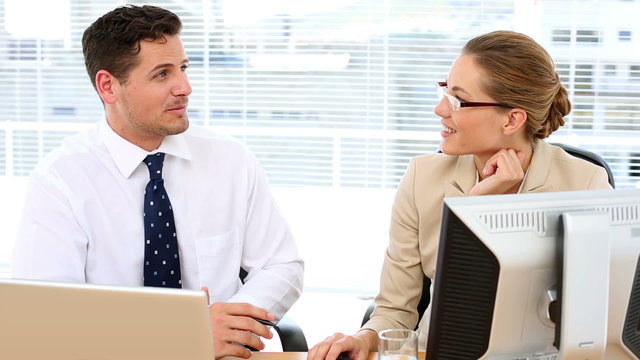 Focused business team speaking together at desk