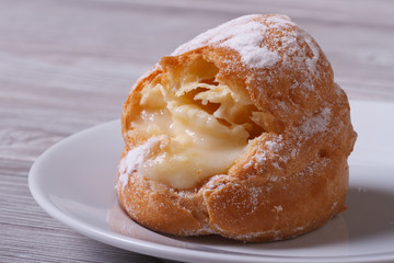 Fresh eclairs with custard on a plate on the table