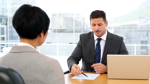 Handsome businessman conducting an interview with businesswoman