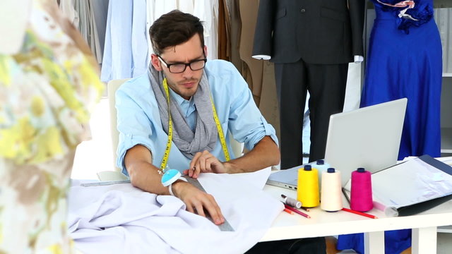 Designer measuring sheet of fabric
